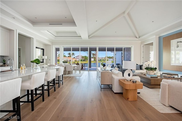 living area with light wood-style floors, beam ceiling, visible vents, and coffered ceiling