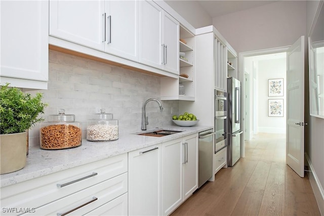 kitchen featuring white cabinetry, a sink, and open shelves