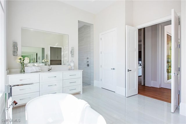 full bathroom featuring tiled shower, a freestanding bath, and vanity