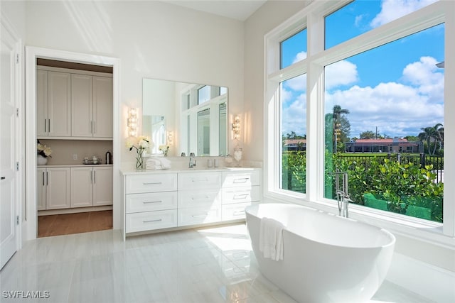 bathroom featuring a soaking tub and vanity