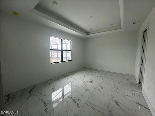 unfurnished room featuring a tray ceiling