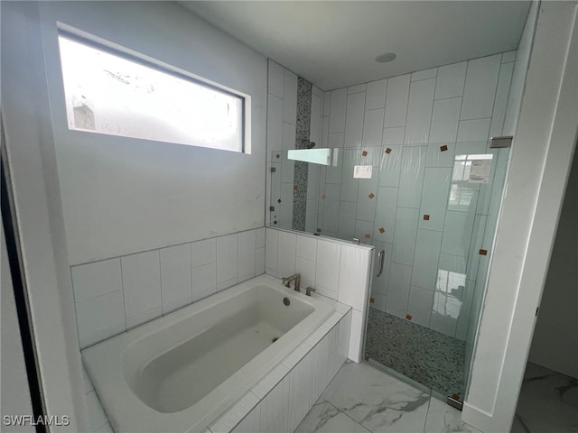 bathroom featuring shower with separate bathtub