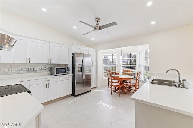 kitchen featuring lofted ceiling, white cabinetry, stainless steel appliances, tasteful backsplash, and sink