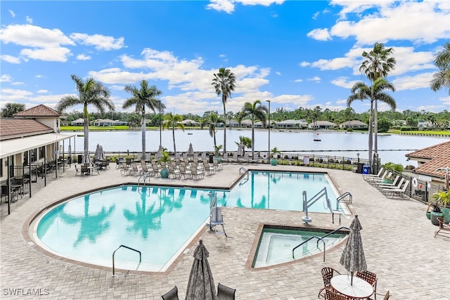 view of swimming pool with a water view and a patio area