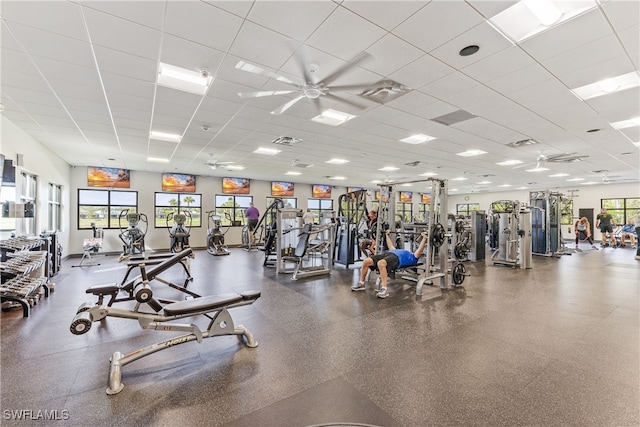 gym with ceiling fan and a drop ceiling