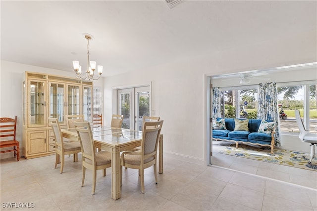 tiled dining room with french doors and an inviting chandelier