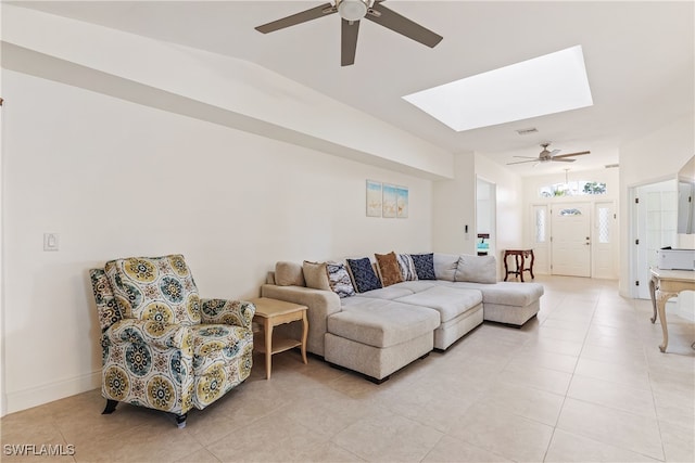 tiled living room featuring ceiling fan and a skylight