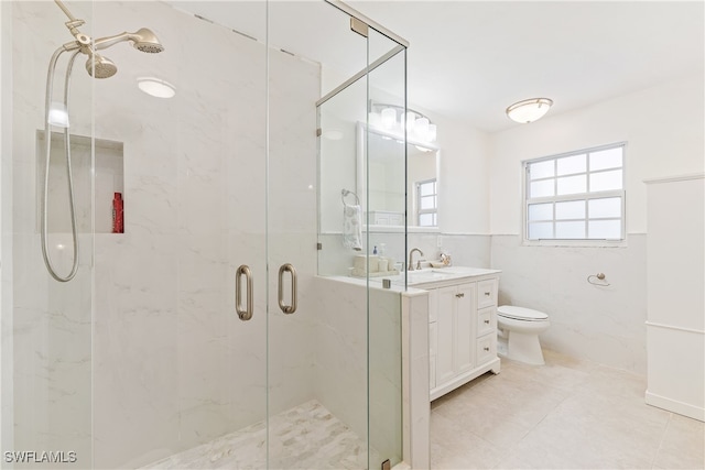 bathroom featuring toilet, vanity, tile walls, tile patterned flooring, and an enclosed shower