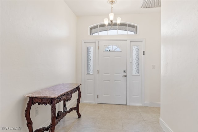 tiled entrance foyer with a notable chandelier