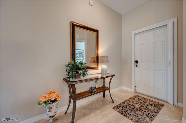 foyer entrance with light tile patterned flooring and baseboards