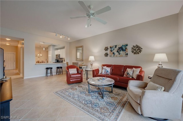 living room with ceiling fan with notable chandelier and light tile patterned floors