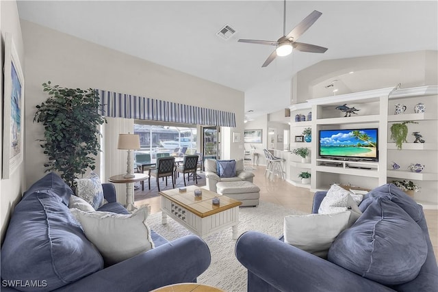 living room with ceiling fan, built in features, light tile patterned flooring, and vaulted ceiling