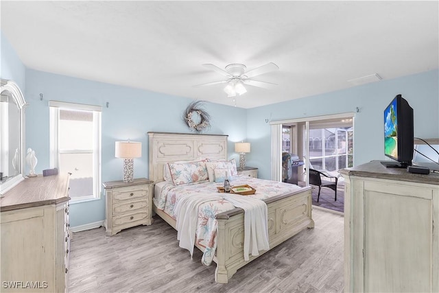 bedroom featuring ceiling fan, light hardwood / wood-style flooring, and multiple windows