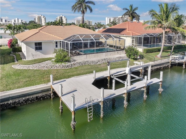 dock area featuring a lanai, a lawn, and a water view