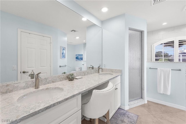 bathroom with tile patterned flooring, vanity, toilet, and an enclosed shower