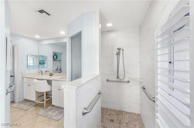 bathroom with tile patterned floors, walk in shower, and sink