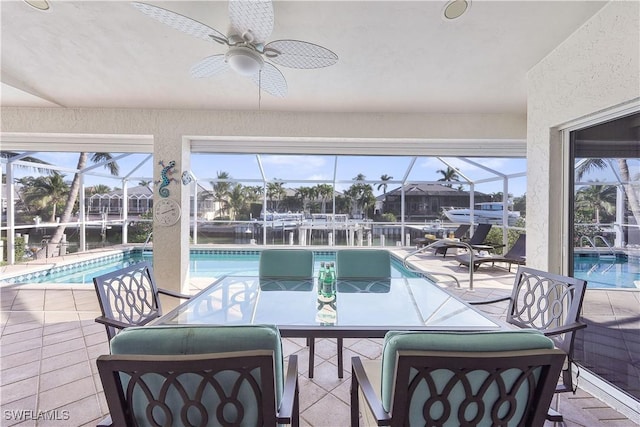 sunroom / solarium with ceiling fan, a water view, and a swimming pool