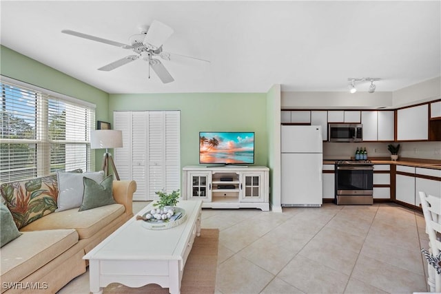 living room featuring light tile patterned floors and ceiling fan