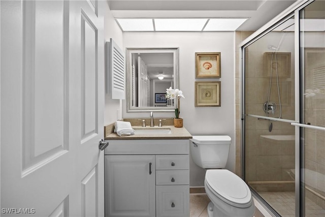 bathroom with vanity, tile patterned flooring, toilet, and walk in shower