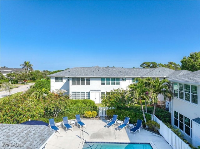 back of house featuring a community pool and a patio area