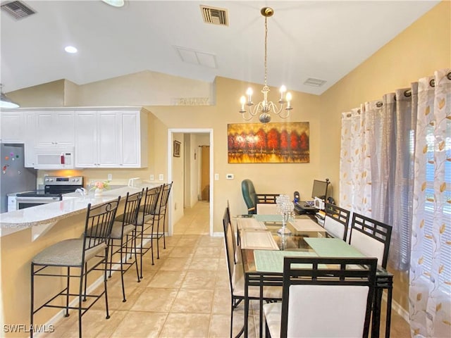 tiled dining room with a notable chandelier and lofted ceiling