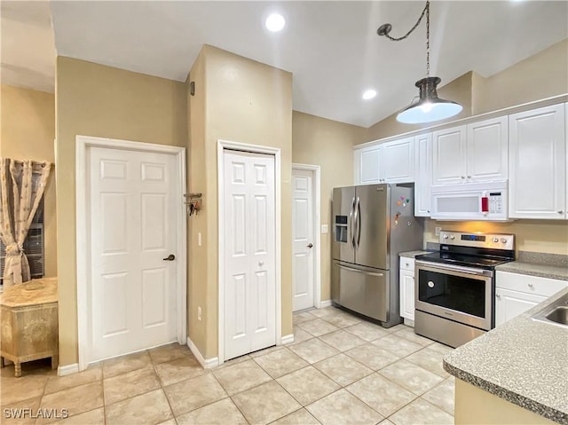 kitchen featuring white cabinets, appliances with stainless steel finishes, light tile patterned floors, and lofted ceiling