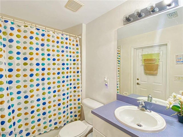 bathroom featuring vanity, toilet, and curtained shower