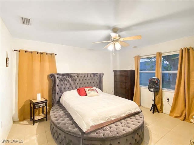 tiled bedroom featuring ceiling fan