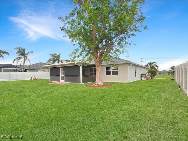 back of house with a lawn and a sunroom