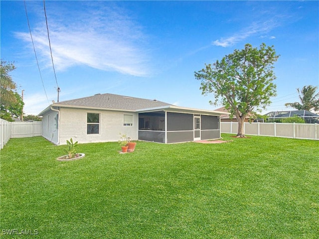 back of property with a lawn and a sunroom