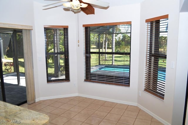 interior space with ceiling fan, light tile patterned floors, and a healthy amount of sunlight