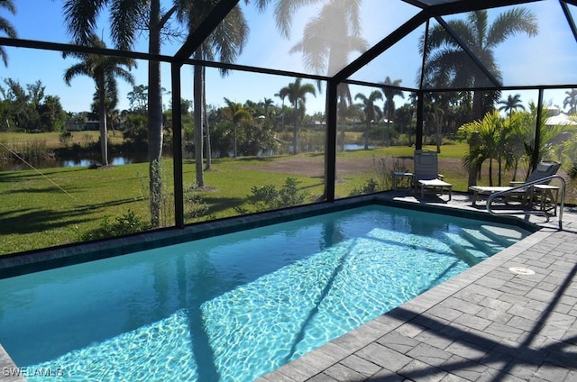 view of pool with a patio, a water view, glass enclosure, and a yard