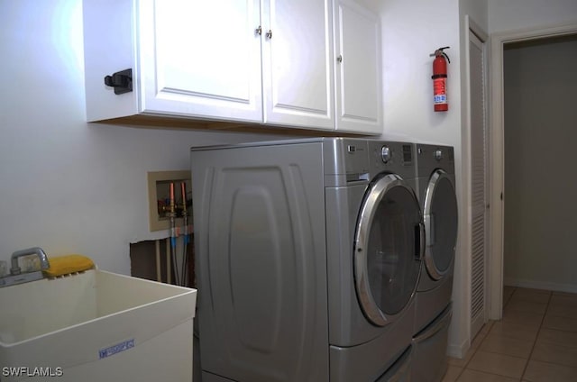 washroom with tile patterned flooring, cabinets, washing machine and clothes dryer, and sink