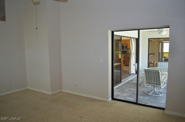 empty room featuring light colored carpet and ceiling fan