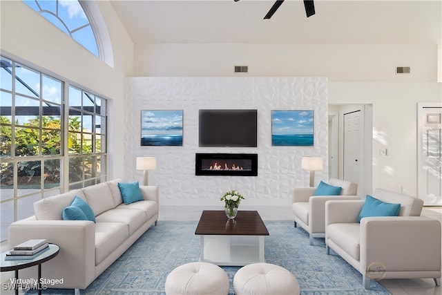 living room with ceiling fan and a large fireplace