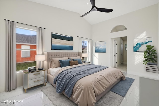 bedroom with ceiling fan, multiple windows, and vaulted ceiling