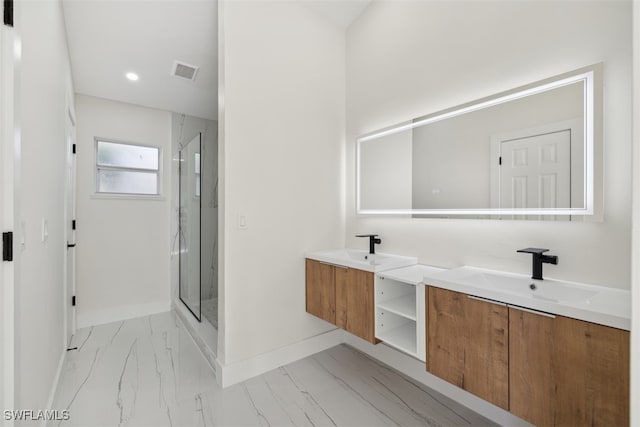 bathroom featuring a shower with door and vanity