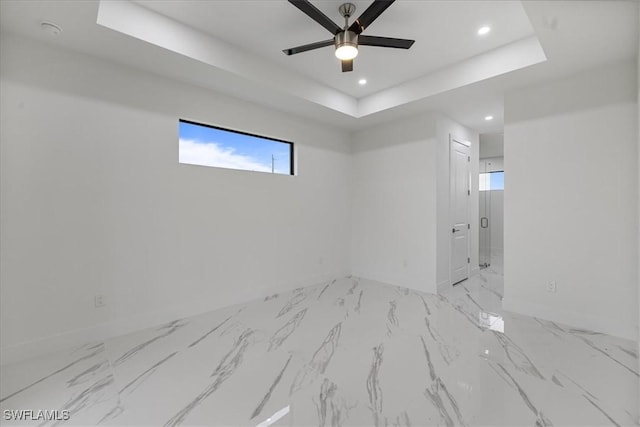 unfurnished room with a raised ceiling and ceiling fan