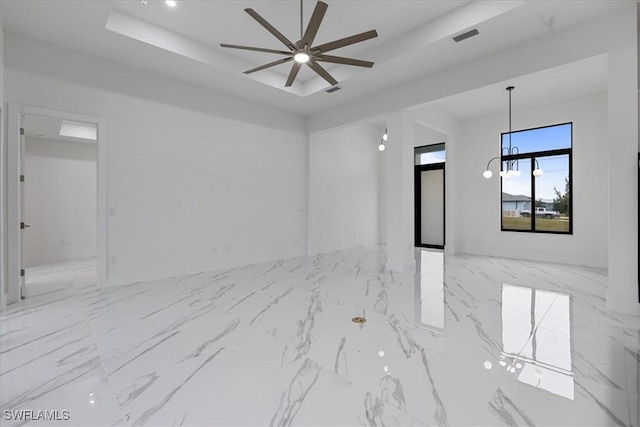 unfurnished room with ceiling fan and a raised ceiling