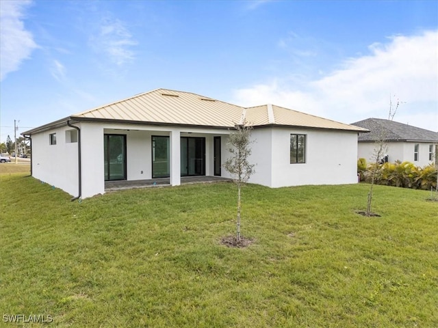 rear view of property featuring a yard and a patio