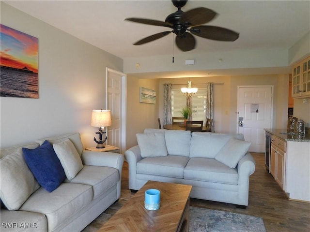 living room featuring dark hardwood / wood-style floors, beverage cooler, and ceiling fan with notable chandelier