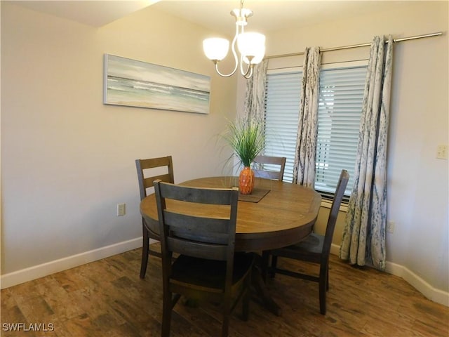 dining room featuring dark hardwood / wood-style flooring and an inviting chandelier