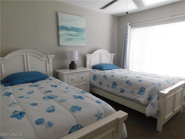 carpeted bedroom with ceiling fan and multiple windows