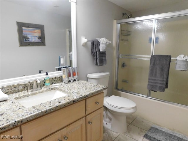 full bathroom featuring shower / bath combination with glass door, tile patterned floors, vanity, and toilet