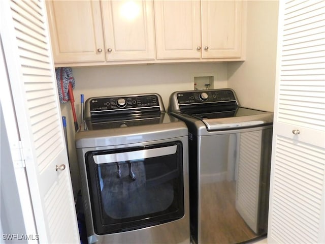 washroom with cabinets and washer and dryer