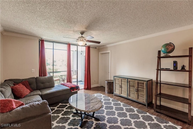 living room with a textured ceiling, ceiling fan, and crown molding