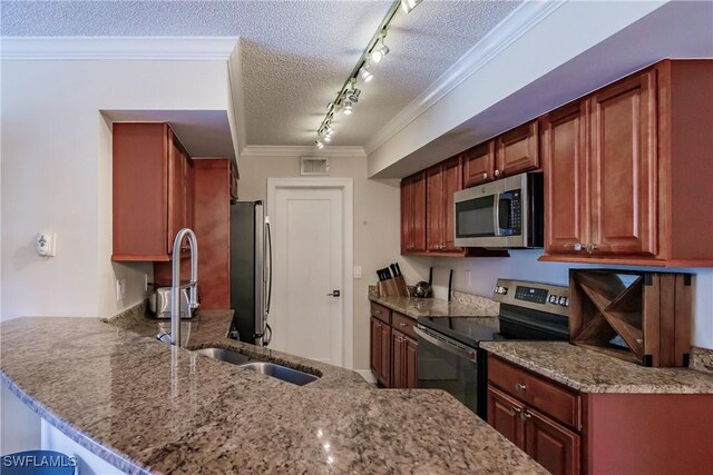 kitchen with rail lighting, appliances with stainless steel finishes, crown molding, kitchen peninsula, and a textured ceiling