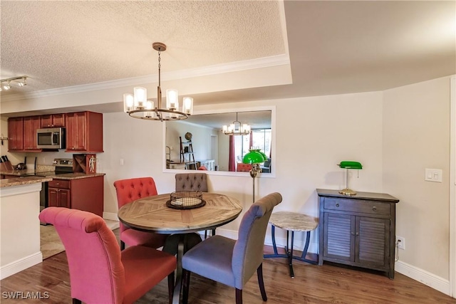 dining room featuring a notable chandelier, dark hardwood / wood-style floors, crown molding, and a textured ceiling