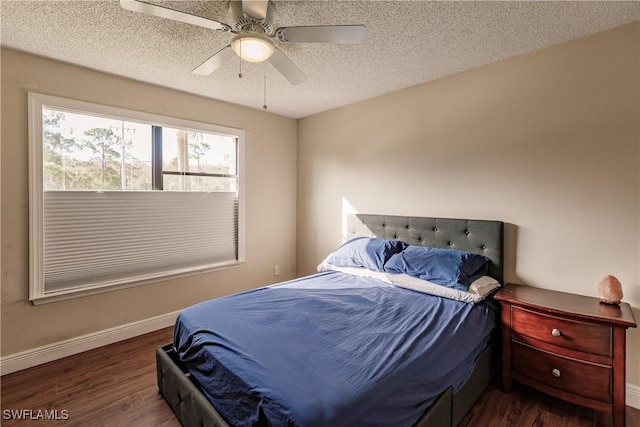 bedroom with ceiling fan, a textured ceiling, and dark hardwood / wood-style floors