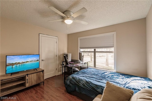 bedroom with dark wood-type flooring, a textured ceiling, and ceiling fan